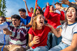 © unai - Young sports fans cheering excitedly in stadium crowd