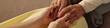 © AnnaStills - Senior Caucasian woman holding hands with young adult Caucasian woman, showing intergenerational connection and support, closeup of hands emphasizing tenderness and care