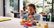 © peopleimages.com - Learning, kid or playing with building blocks in home for fine motor skills, problem solving or creativity. Education, african boy and toys on table for cognitive development and sensory imagination