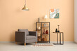 © Pixel-Shot - Stylish grey armchair with shelving unit and golden hanging lamp in modern room
