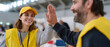 © perfectlab - Volunteers wearing yellow vests and cap giving high five in a bright indoor community center during a charity event or social gathering