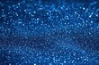 © Olya - Close-up of sparkling blue glitter particles creating a shimmering and festive visual texture with a bokeh effect