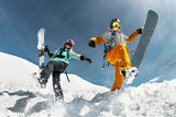 Two happy young snowboarders are having fun and jumps with snowboards from snowdrift. Winter vacations at ski resort concept