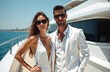 © miss irine - Wealthy couple poses on yacht in summer. Elegant woman wears white dress. Confident man wears suit. Vacation lifestyle is about sea travel and happiness. Couple enjoying cruise vacation.