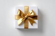 © ibtesam - White gift box with golden ribbon isolated on white background, top view