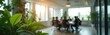 © miss irine - Business people meet around table in bright modern office. Green plants add life to meeting room setting. Natural light fills the space through large windows.