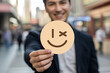 © Pixel Studio - Smiling man in a suit holds a winking emoji sign in a busy city street conveying a playful and positive message with a modern and approachable style for social media marketing campaigns