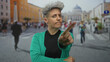 © Krakenimages.com - Woman with short hair and green cardigan points finger on street amid crowds in front of baroque facade; defiance.