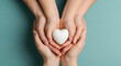 © Sehar - Family holding a white heart in their hands on a blue background, love and care concept