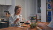 © stockbusters - Married couple eating dinner in cozy kitchen. Smiling woman talking husband