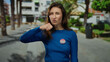 © Krakenimages.com - Woman in blue shirt with vote badge gestures on city street expressing frustration outdoors in united states.