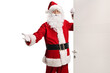 © Ljupco Smokovski - Santa Claus opening a door and gesturing welcome