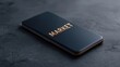 © FocusFusion - Mobile Device Displaying the Word Market on a Dark Textured Surface in a Contemporary Style