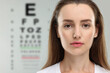 © New Africa - Eye chart and young woman on grey background. Vision check