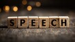 © Tina - Wooden blocks arranged to spell the word 'SPEECH' on a rustic wooden surface with blurred lights in the background.