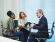 © Singh - Business meeting in modern office three professionals having a business meeting in a modern office, discussing ideas with a tablet and coffee on the table.