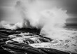 © MdKamran - Ocean wave crashing on rocks in black and white dramatic seascape shot