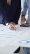 © rogerphoto - Professional team reviewing financial documents, pointing at charts on desk, collaborating to analyze data and strategize business growth. Business people concept