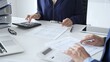 © rogerphoto - Business team of male and female accountants analyzing financial documents, using calculators and laptop, working together on project in modern office. Audit and taxes concept