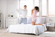 © Pixel-Shot - Happy young beautiful couple fighting pillows in bedroom