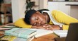 © Lawrenson25/peopleimages.com - Sleeping, student and books with black woman in home for burnout, mental health and college deadline. Studying fatigue, overworked and education with person in apartment for resting, workload or nap