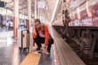 © Tj - Traveler feeling stressed and hopeless on a train station platform, holding head while a train departs, representing missed connection and travel problems