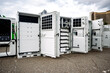 © dizfoto1973 - Modular energy storage system and EV charging infrastructure revealed, showcasing advanced electrical components and modern technology under a cloudy sky.