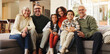 © Wess/peopleimages.com - Grandparents, parents and children on sofa for portrait in home for love, relationship or bonding. Interracial family, generations and kids with mom, dad and senior people for trust, support or relax