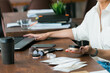 © satura_ - Woman holding cosmetic jar with mineral powderat wooden desk with laptop and coffee cup. Balance between work and self-care, illustrating modern lifestyle and routine.