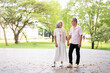 © Fahng - Romantic and elderly healthy lifestyle concept.Senior active asian couple holding hands looks happy in the park in the morning spring sunlight,happily retired with copy space.