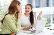 © Fahng - Young businesswomen sit at desk in office work together on laptop discuss ideas. female employees colleagues brainstorm on computer at meeting. Teamwork concept.