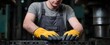 © ckybe - Metalworker uses industrial press while wearing protective gloves for safety.