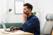 © New Africa - Man working on laptop at table in office