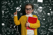 © New Africa - Cute little child in glasses near green chalkboard with drawings