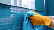 © Александр Марченко - Hands in gloves cleaning blue tiles with a cloth
