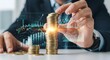 © Mst - Businessman stacking gold coins with financial graph overlay for investment and finance growth strategy in business concept, money saving plan