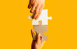 © Yevhen - Closeup hands of man connecting jigsaw puzzle. Two hands trying to connect couple puzzle with yellow background. Hand connecting jigsaw puzzle. Man hands connecting couple puzzle piece
