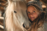Equine assisted therapy with child and horses on animal farm. Little girl embracing white pony horse while her mother is watching them