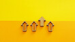 © Andrii - Wooden arrows pointing up on yellow background - business growth, leadership and competitive advantage concept