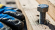 © ManuStockStudio - Close up of a metal bolt secured in a wooden plank with a gloved hand in the background representing construction and DIY projects