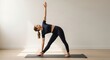 © Mr. Stocker - Caucasian female adult practicing yoga. Trikonasana triangle pose for flexibility. Mindful fitness routine in a bright studio. Wellness journey and body balance concept