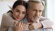 © Natti - A heartwarming and intimate close-up portrait of a younger Caucasian woman embracing an older, middle-aged Caucasian man from behind.