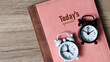 © Shanorsila - Today's Agenda Concept with Pink Planner, White and Black Alarm Clocks for Daily Schedule.