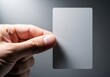 © MDJamir - Hand holding blank credit card or access card close up in studio lighting with soft focus background