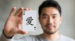 © musa - A man holding an ace of spades playing card with a Chinese character symbol in a close-up shot, demonstrating a gesture of love or affection in a casual setting