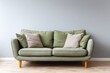 © free - Green sofa with pillows sits against a pale blue wall.