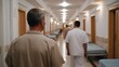 © Bussakon - Men walking down a long institutional hallway lined with beds