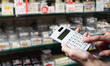 © mnimage - Close-up of a hand calculating with a calculator at a supermarket.