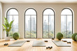 © ImageFlow - Modern yoga studio interior with arched windows, wooden floor and city view, fitness mats and green exercise balls arranged in minimalist design. 3D Rendering