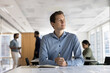 © fizkes - Thoughtful smiling young man look aside of documents on desk